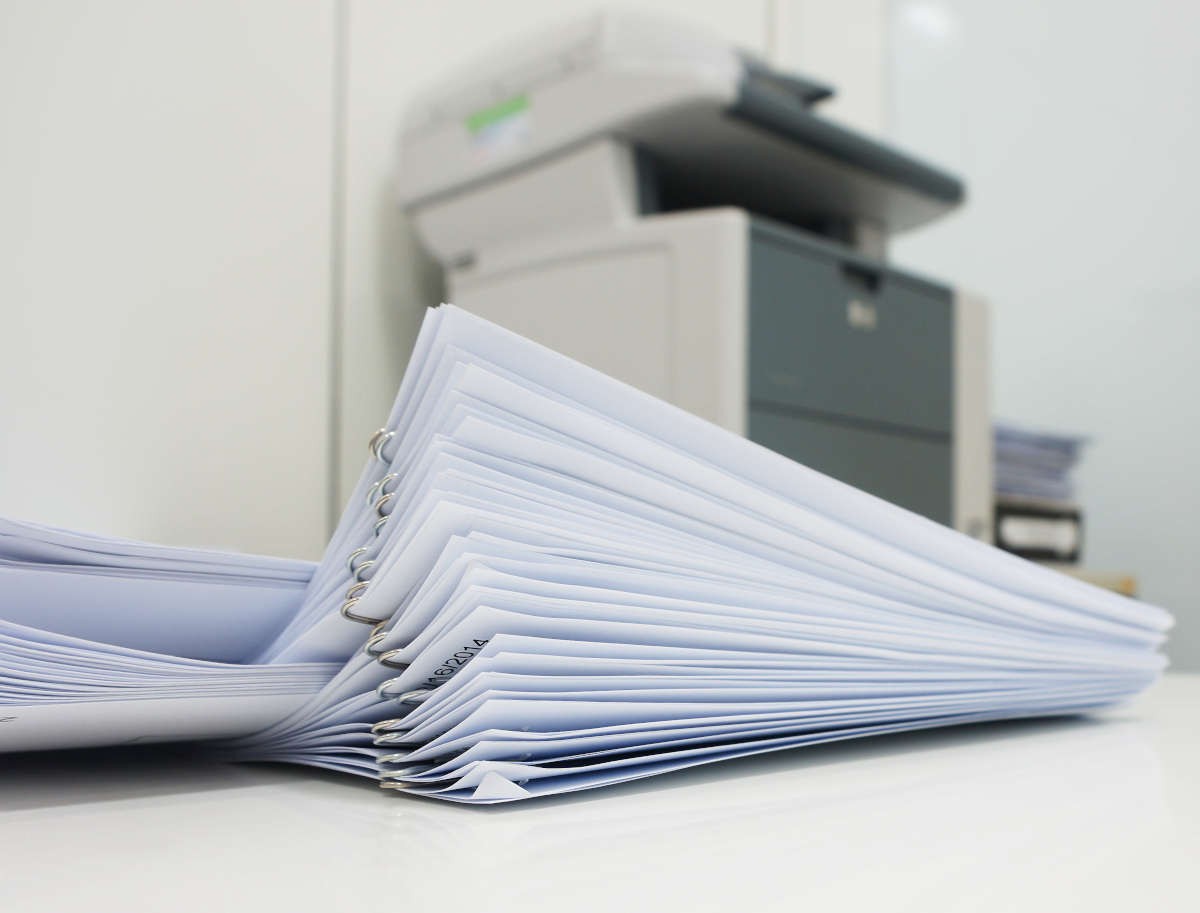 Stack of documents in front of a copier